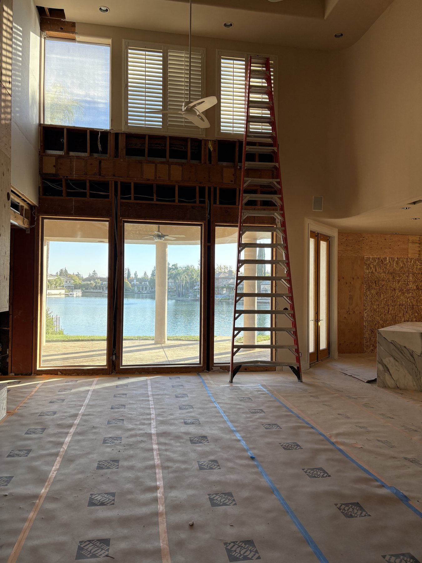 Lakeside residential renovation in progress with protected floors and opened walls