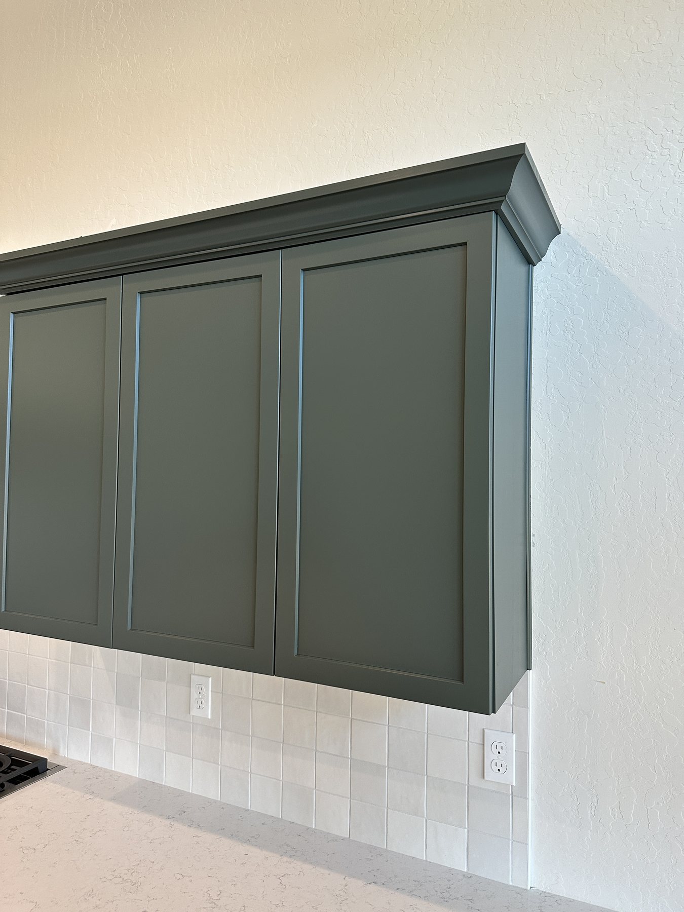Tailored green painted cabinetry with crown molding